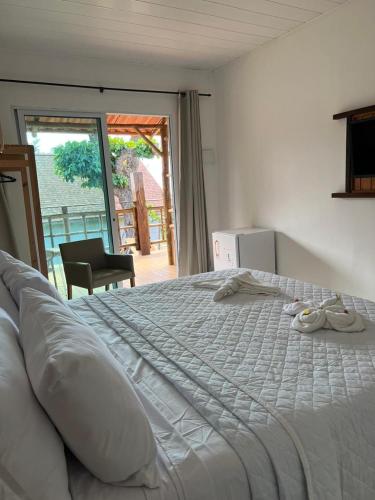a large white bed in a room with a window at Pousada do Nativo in Fernando de Noronha