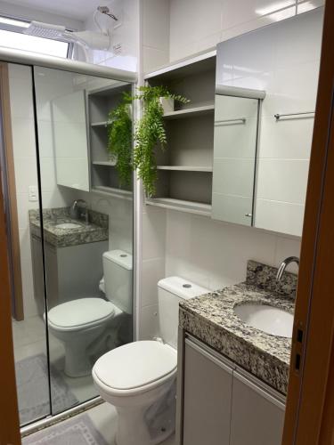 Baño blanco con aseo y lavamanos en SPAZIO LA VITTA LONDRINA, en Londrina