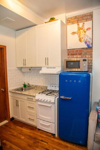 a kitchen with a blue refrigerator and a stove at The Harlem Getaway in New York