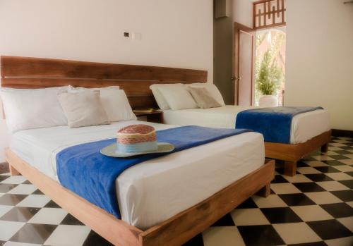 a bedroom with two beds with a hat on it at La Puerta Azul in Santa Marta