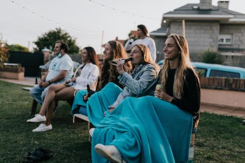 a group of people sitting on chairs in a yard at Gijon Surf Hostel in Gijón