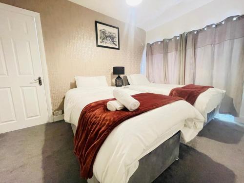 Charming 3-Bed holiday House in Birmingham في برمنغهام: غرفة نوم بسريرين عليها مناشف