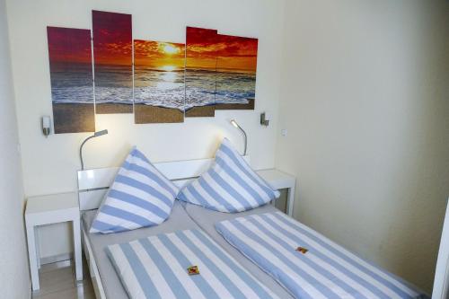 a bed with two blue and white pillows on it at Strandhochhaus SB10 in Cuxhaven