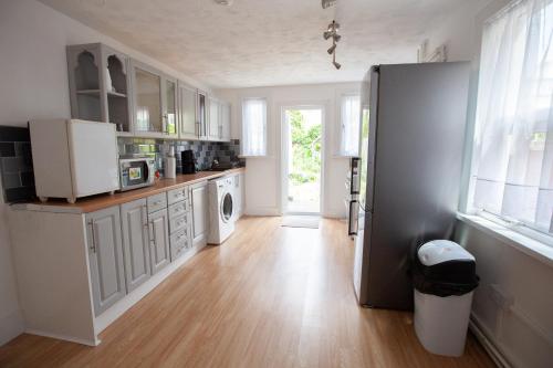 eine Küche mit weißen Schränken und einem Kühlschrank in der Unterkunft Beach palace in Clacton-on-Sea