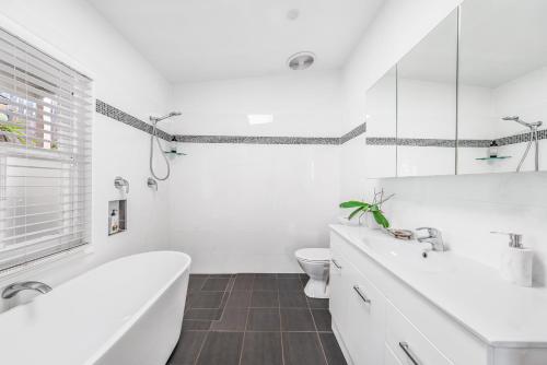 uma casa de banho branca com uma banheira e um WC em COOK3R - Character on Cook Street em Sydney