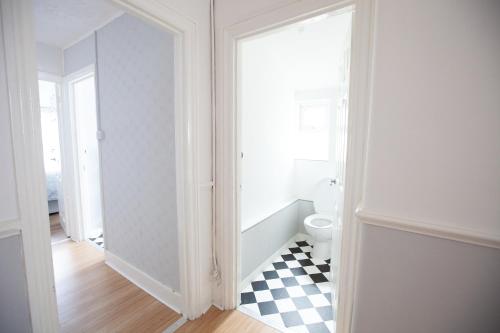 a bathroom with a toilet and a checkered floor at Beach palace in Clacton-on-Sea