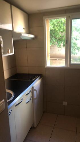 eine kleine Küche mit einem Waschbecken und einem Fenster in der Unterkunft MISSYT in Colombes