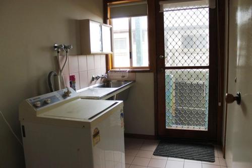 a small kitchen with a sink and a refrigerator at Family Holiday House with Open Plan Living in Cowes