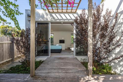 a garden with a wooden walkway leading to a bedroom at Boofs At Blueys in Blueys Beach