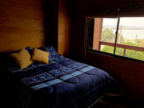 a bedroom with a bed and a window with a view at Tongoy Beach Tinyhouse in Tongoy