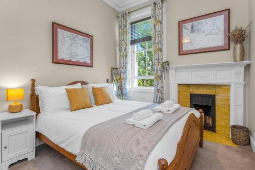 1 dormitorio con 1 cama y chimenea en Marchmont Traditional Apartments, en Edimburgo