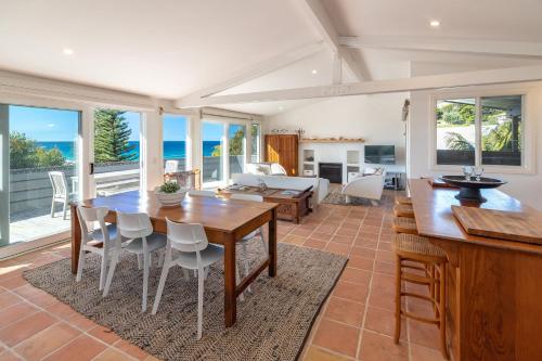 a kitchen and living room with a table and chairs at Aqua View in Boomerang Beach