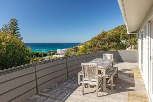 a table and chairs on a balcony with the ocean at Aqua View in Boomerang Beach