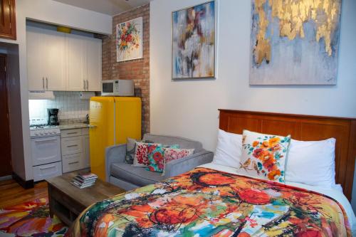 a small bedroom with a bed and a kitchen at The Harlem Getaway in New York