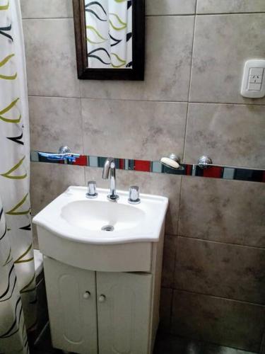 y baño con lavabo blanco y espejo. en Departamento 2 ambientes en La Plata