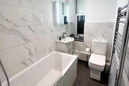 uma casa de banho com uma banheira, um WC e um lavatório. em Windsor Apartment em Brighton & Hove