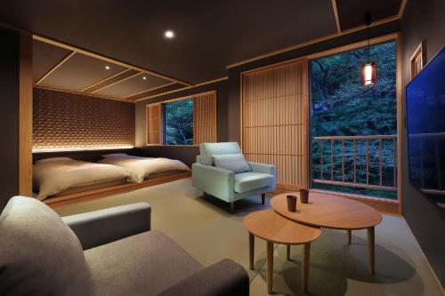 ein Wohnzimmer mit einem Sofa, einem Bett und einem Tisch in der Unterkunft Moritaya in Koriyama
