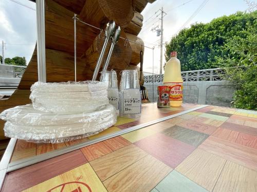 a table with glass bottles on top of a wooden floor at 憩いの場　ただいま〜 in Nago