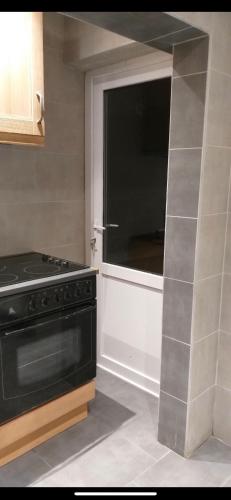 a kitchen with a black stove and a window at H Bruxelles airport Charleroi Harmonie in Charleroi
