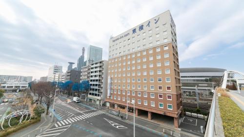 a tall building on a street in a city at Toyoko Inn Saitama Shintoshin in Saitama