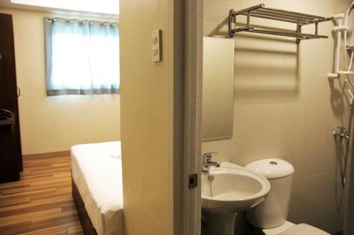 łazienka z umywalką, toaletą i łóżkiem w obiekcie Happytelle w mieście Dipolog