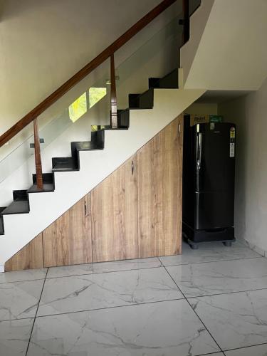 a kitchen with a staircase and a refrigerator at Serene stay in the lap of Nature in Ahmedabad