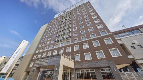 a tall brown building with a building at Toyoko Inn Tokuyama-eki Shinkansen-guchi in Shunan