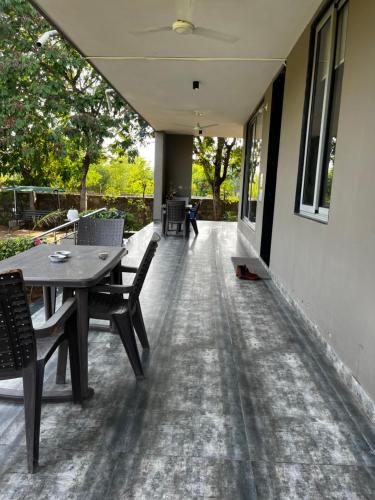 a patio with a wooden table and chairs on it at Serene stay in the lap of Nature in Ahmedabad
