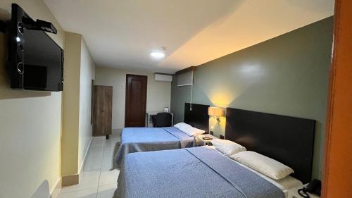 a hotel room with two beds and a flat screen tv at Hotel Varadero Internacional in Guayaquil