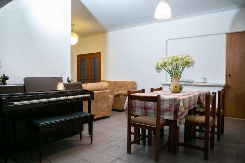 ein Wohnzimmer mit einem Klavier und einem Tisch in der Unterkunft Casa Lili in Oaxaca de Juárez