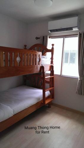 two bunk beds in a bedroom with a window at Muang Thong Home for Rent in Ban Bang Phang