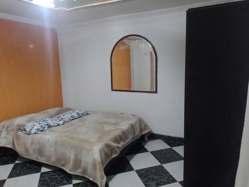 a bedroom with a bed and a checkered floor at Habitacion cerca iglesia veinte Julio in Bogotá