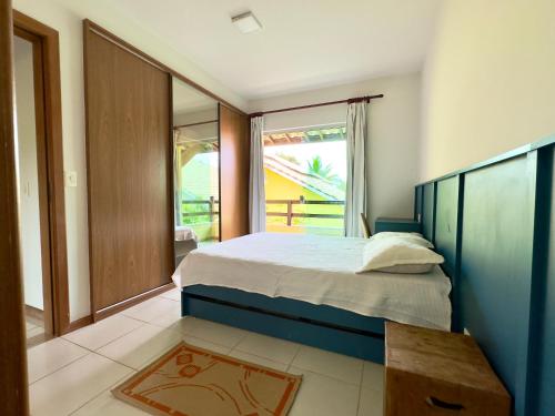 ein Schlafzimmer mit einem Bett und einem großen Fenster in der Unterkunft Breeze 09 Imbassaí in Imbassai