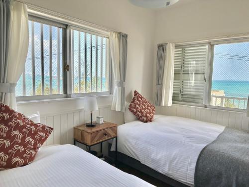a bedroom with two beds and a view of the ocean at Fortuna YAKA in Kin
