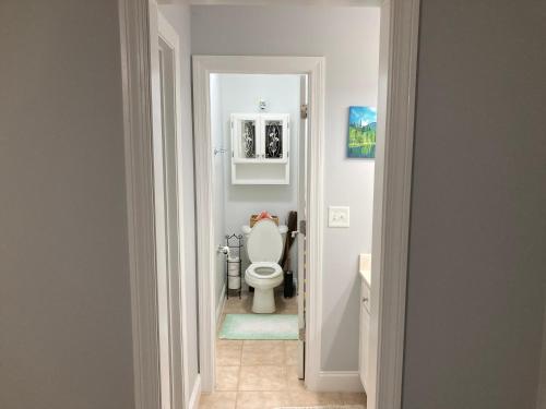 a white bathroom with a toilet in a hallway at Casa Cool in Braselton
