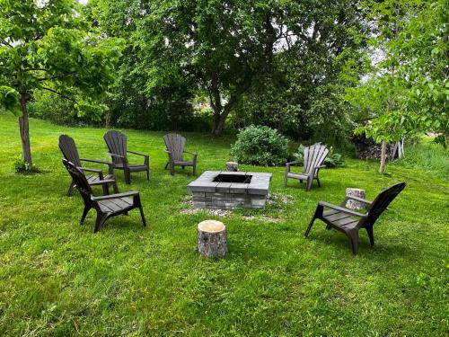 a group of chairs and a fire pit in the grass at Auberge musicale Pour un Instant in La Malbaie