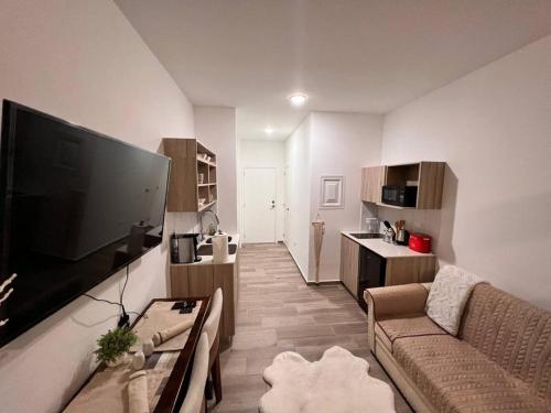 a living room with a couch and a large flat screen tv at Narama Luxury near to the airport in Guatemala