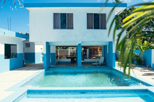 a villa with a swimming pool in front of a house at Parador El Ermitaño in Santa Bárbara de Samaná