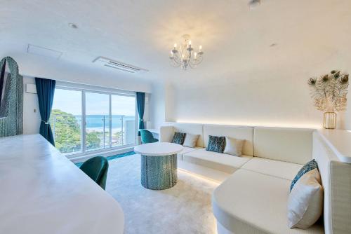 a living room with a white couch and a table at Hotel Sea Shell in Shimoda