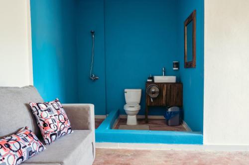 a blue room with a toilet and a couch at Parador El Ermitaño in Santa Bárbara de Samaná