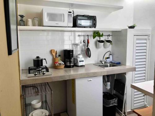 eine kleine Küche mit einer Spüle und einer Mikrowelle in der Unterkunft Apartaestudio#7 ITESM aire acondicionado sin cochera in Laborcillas