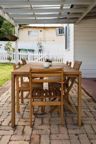 a wooden table and chairs on a patio at The Hunter House c1917 in Cessnock