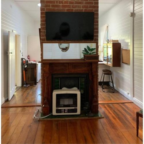 a living room with a tv on top of a fireplace at The Hunter House c1917 in Cessnock