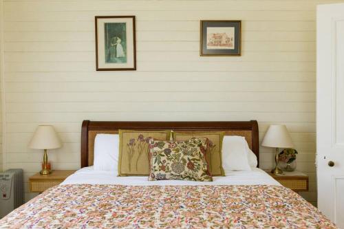 a bedroom with a bed with two lamps and two pillows at The Hunter House c1917 in Cessnock