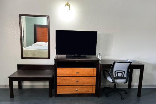 a desk with a television and a chair in a room at Regency Inn Bald Knob in Bald Knob