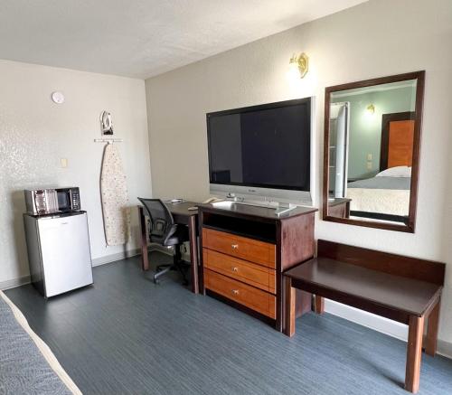 a hotel room with a television and a desk with a mirror at Regency Inn Bald Knob in Bald Knob
