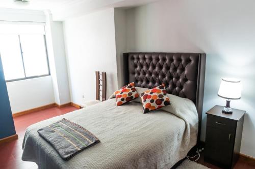 a bedroom with a large bed with two pillows on it at Elegante y Funcional Apartamento en zona comercial de Sopocachi in La Paz