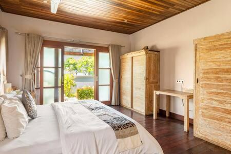 une chambre avec un grand lit et une fenêtre dans l'établissement Villa Agung, à Nusa Lembongan
