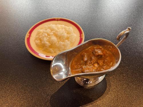 a pot of food and a bowl of rice at Hotel Nakamuraya in Shiojiri