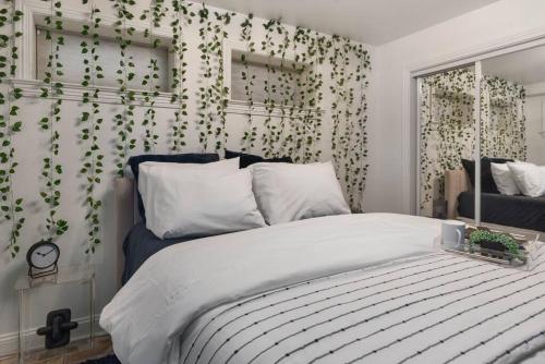 um quarto com uma cama com folhas verdes na parede em Upscale 2BR Apartment with Patio em Washington